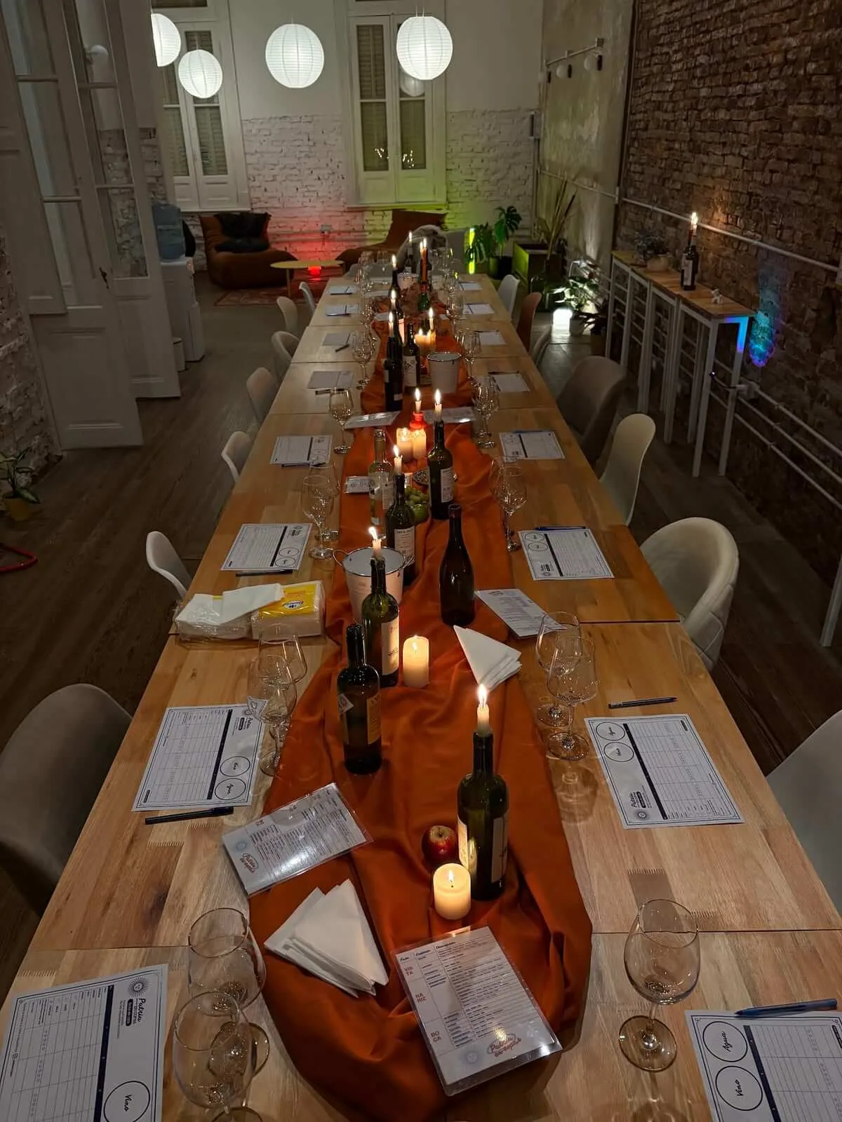 Mesa armada para una cata en La Casa, con botellas, velas y copas
