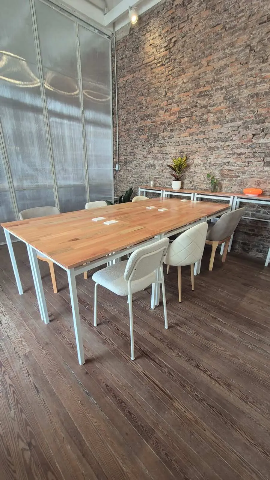 La sala de reuniones privada, con mesa de madera, sillas y plantas
