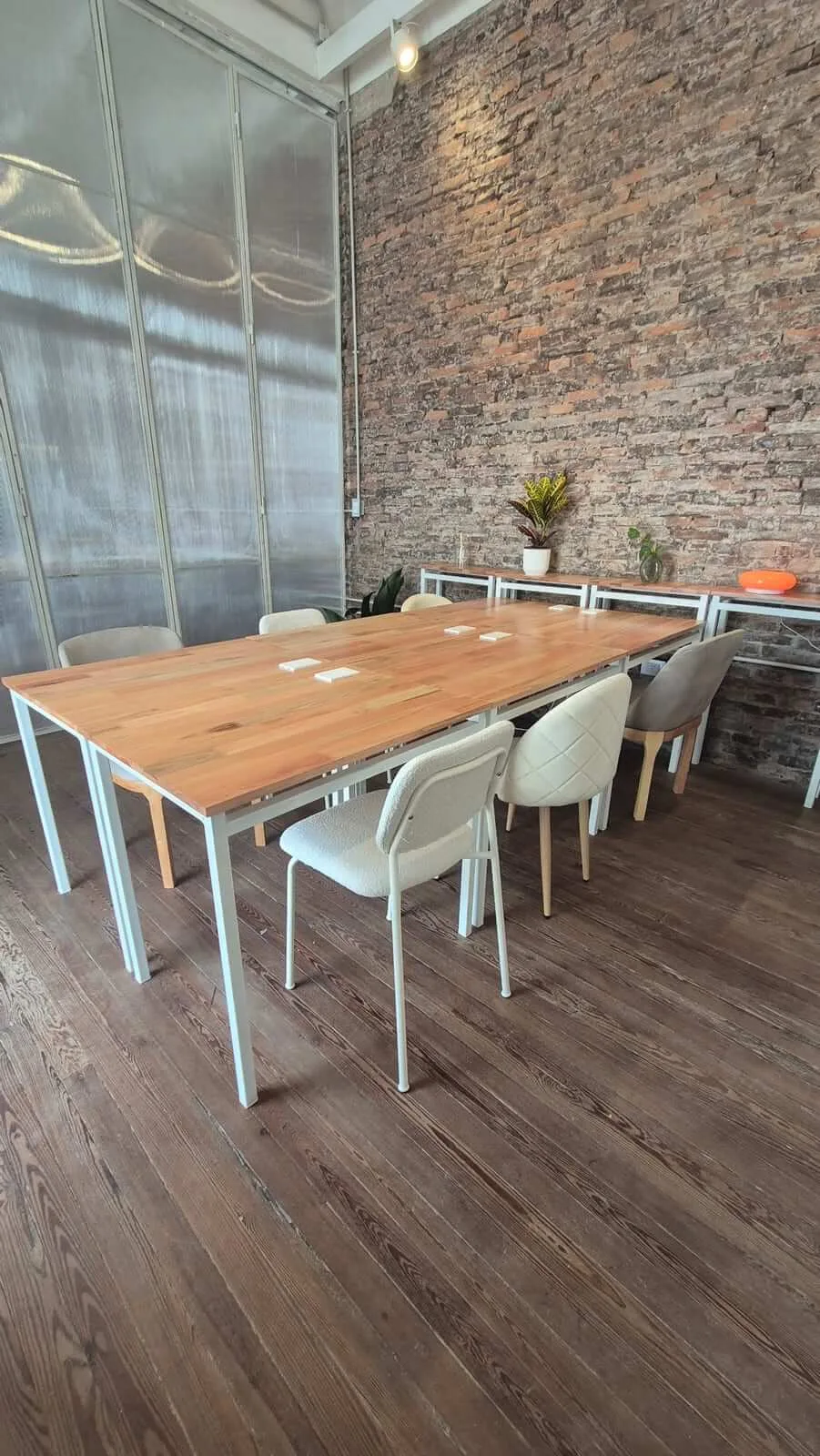 La sala de reuniones privada de La Casa, con mesa de madera, sillas y plantas